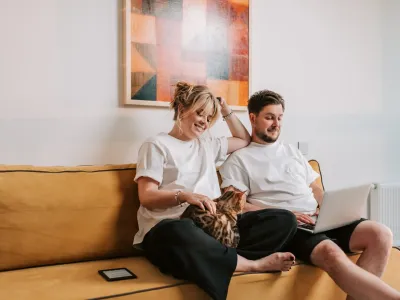 Jong koppel met laptop in de zetel