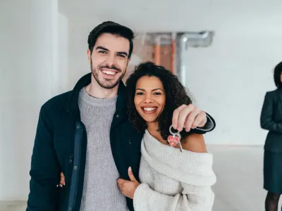 Lachend koppel met de sleutel van hun nieuwe woning
