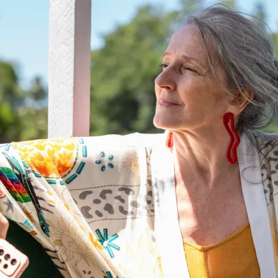 mooie oudere dame die uit raam kijkt en glimlacht 