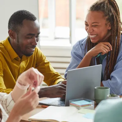 Een groep mensen die aan tafel iets aan het bespreken zijn