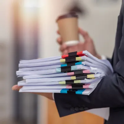 Iemand die een stapel papieren vasthoudt