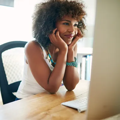 Jonge vrouw die naar computerscherm kijkt