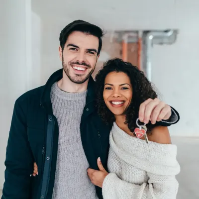 Lachend koppel met de sleutel van hun nieuwe woning