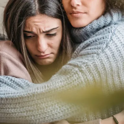 Twee vrouwen troosten elkaar