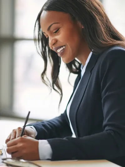 Een glimlachende vrouw die een document ondertekent