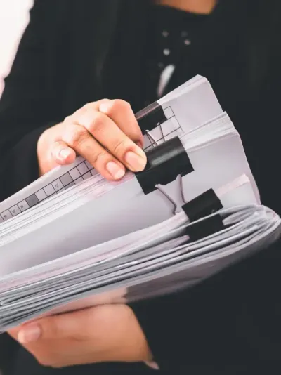 vrouw die verschillende dossiers vasthoudt