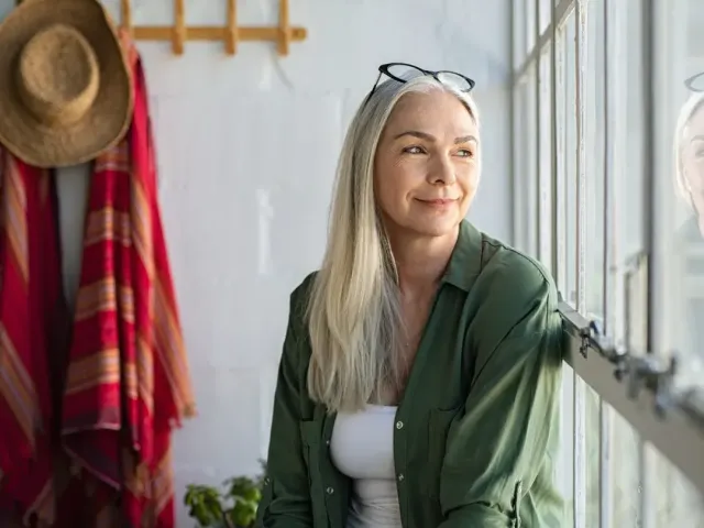 vrouw kijkt uit het raam